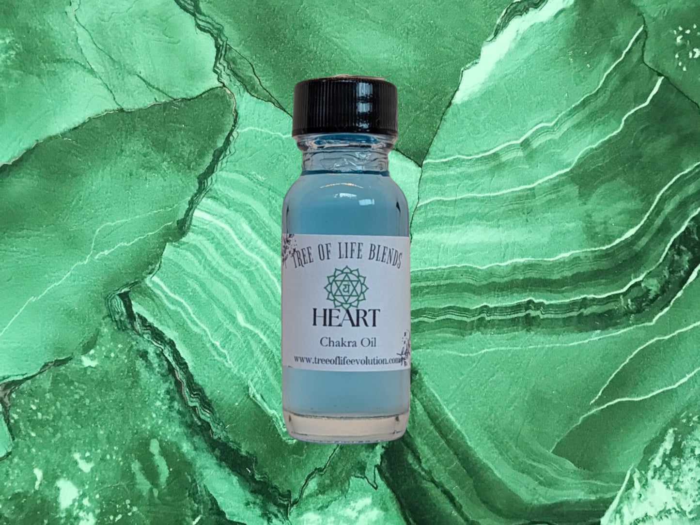 Heart chakra oil from Tree of Life Evolution on green background